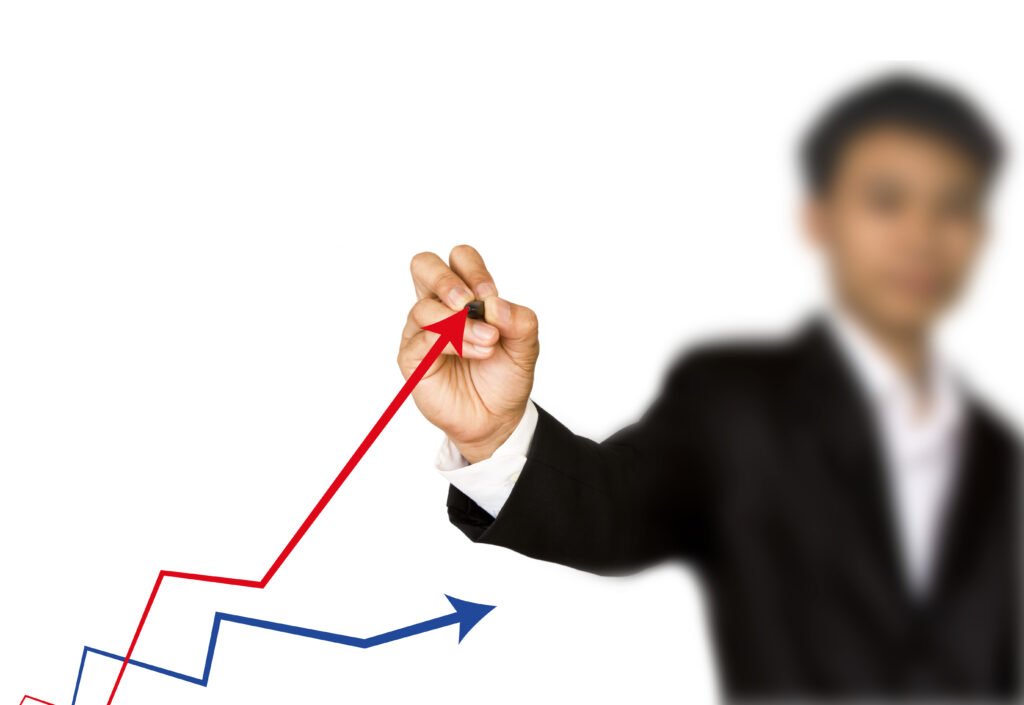 Business professional drawing a rising upward arrow on a growth chart to represent continuous improvement and industrial success.