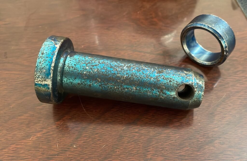 A matched set of industrial-grade pins and bushes with a blue-tempered finish, essential for the high-wear joints of various Railway Components.